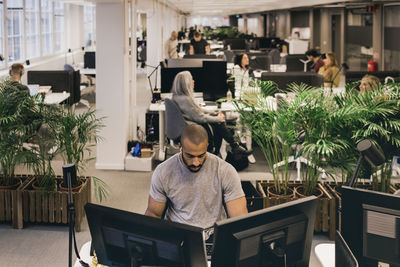 High angle view of creative professional working on computers at desk in office