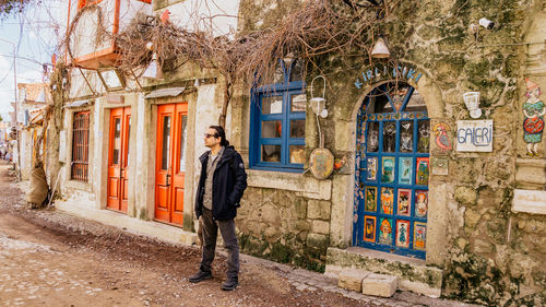 Full length portrait of man standing against building