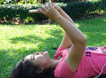 Midsection of man using mobile phone in grass