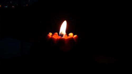 Close-up of lit candle in dark room