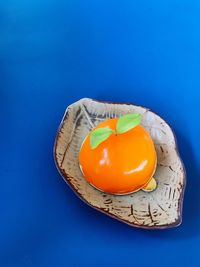 High angle view of orange slice against blue background