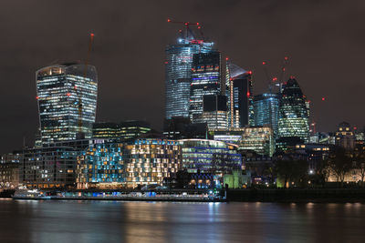 Illuminated buildings in city against sky at night