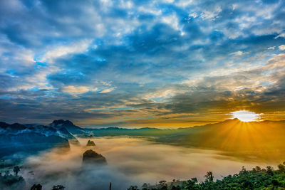 Sunlight streaming through clouds over landscape