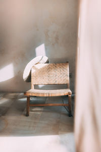 Empty chair and table against wall at home