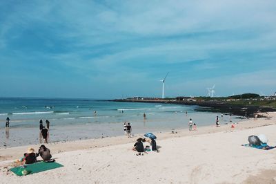 Rear view of people sitting on beach