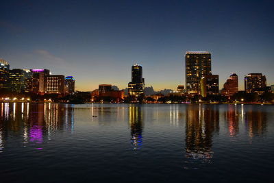 Illuminated buildings in city against sky at night