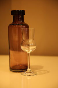 Close-up of empty wineglass and bottle on table