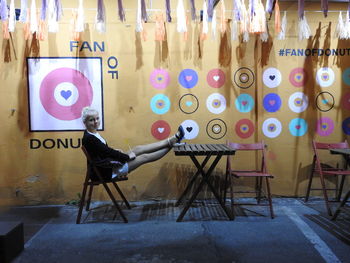 Full length of girl sitting on chair at cafe