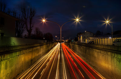 Light trails on road against sky at night