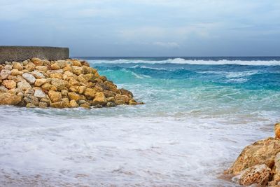 Scenic view of rocks in sea against sky