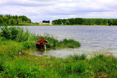 Scenic view of lake against cloudy sky