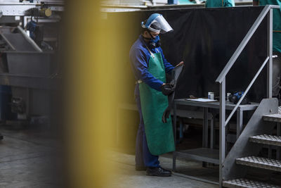 Worker wearing protective mask in factory