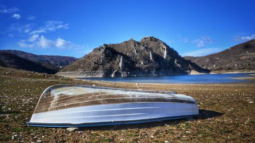 Scenic view of lake and mountains against blue sky