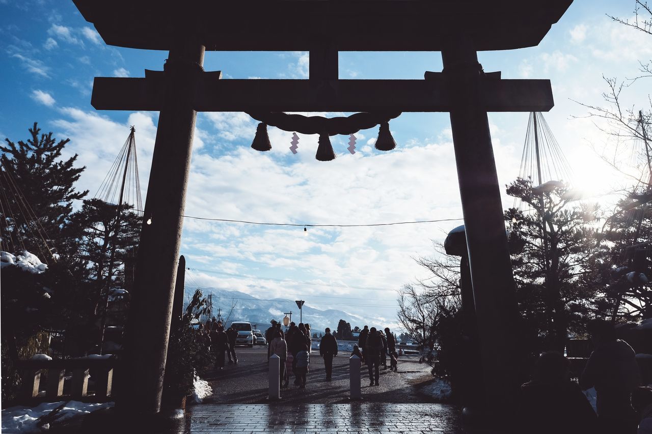 tree, plant, nature, sky, day, cloud - sky, belief, religion, architecture, group of people, water, spirituality, outdoors, built structure, silhouette, real people, low angle view, men, crowd