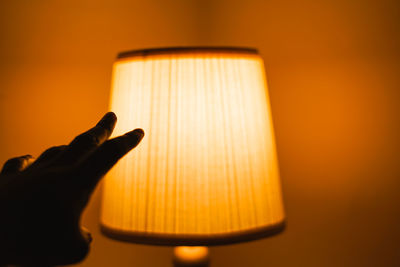 Close-up of hand holding illuminated lamp