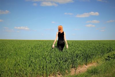 Woman standing on field against sky