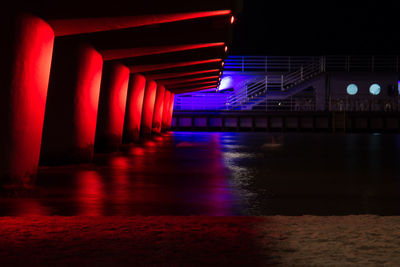 Illuminated underground walkway at night