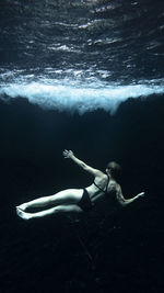 Rear view of woman swimming in sea