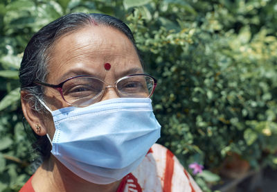 Portrait of an aged indian woman wearing surgical face mask due to covid-19 pandemic.