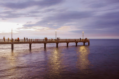 Bridge over river against cloudy sky