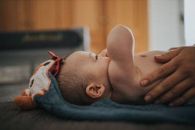 Close-up of baby lying on bed at home