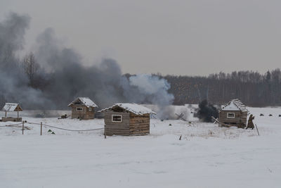 Houses on snow covered landscape against sky