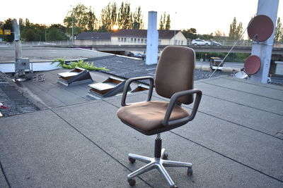 Empty chairs by swimming pool in city