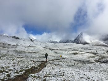 People on snow covered mountain against sky