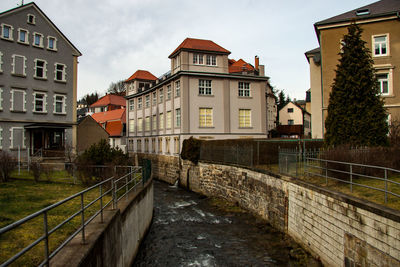 Canal amidst buildings against sky