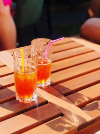 Cropped hand of woman holding drink on table