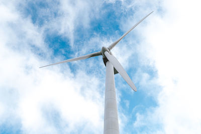 Low angle view of wind turbine against cloudy sky