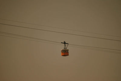 Low angle view of overhead cable car against sky during sunset