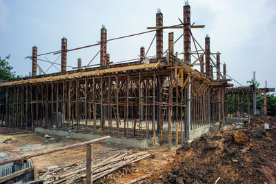 Perspective of house structure under construction at site with blue sky background