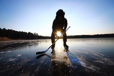 Silhouette man playing ice hockey