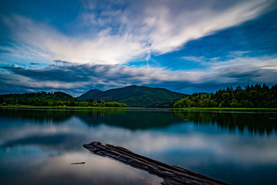 Scenic view of lake by mountains against sky