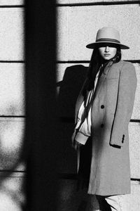 Portrait of woman standing against wall
