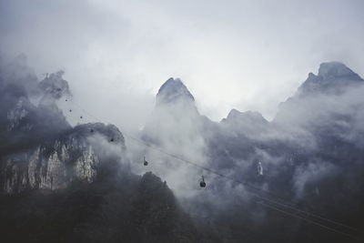 Scenic view of foggy mountain with cable car