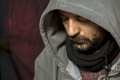 Close-up of man wearing hood clothing in darkroom