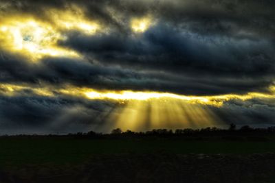 Storm clouds over landscape during sunset