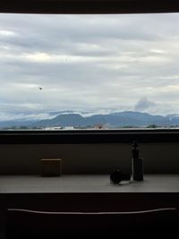 Close-up of window against mountain range