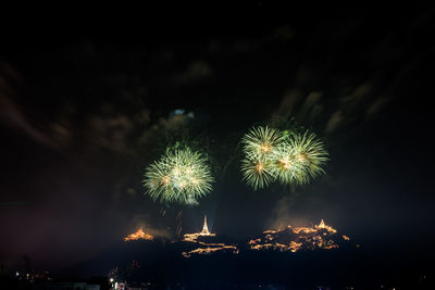 Low angle view of firework display at night