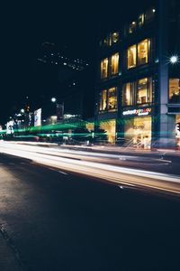 Light trails on road along buildings at night