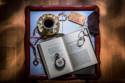 Directly above shot of book with coffee in tray