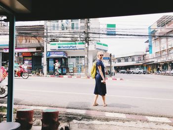 Full length of woman standing on road