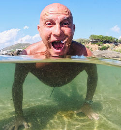 Portrait of man making face while swimming in sea