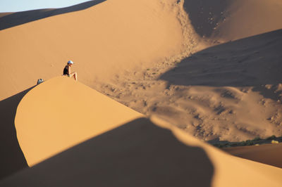 Person sitting on sandy desert