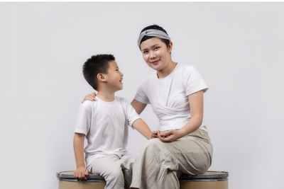 Smiling boy sitting against white background