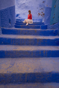 High angle view of man sitting on staircase in city