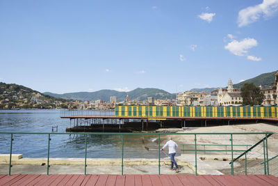 Rear view of man on boat against sky