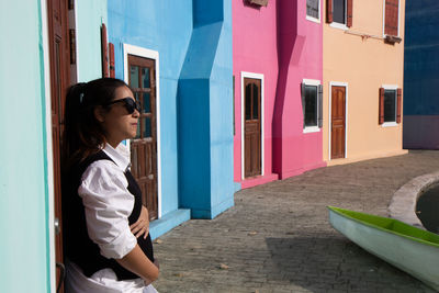 Side view of pregnant women standing against colorful building